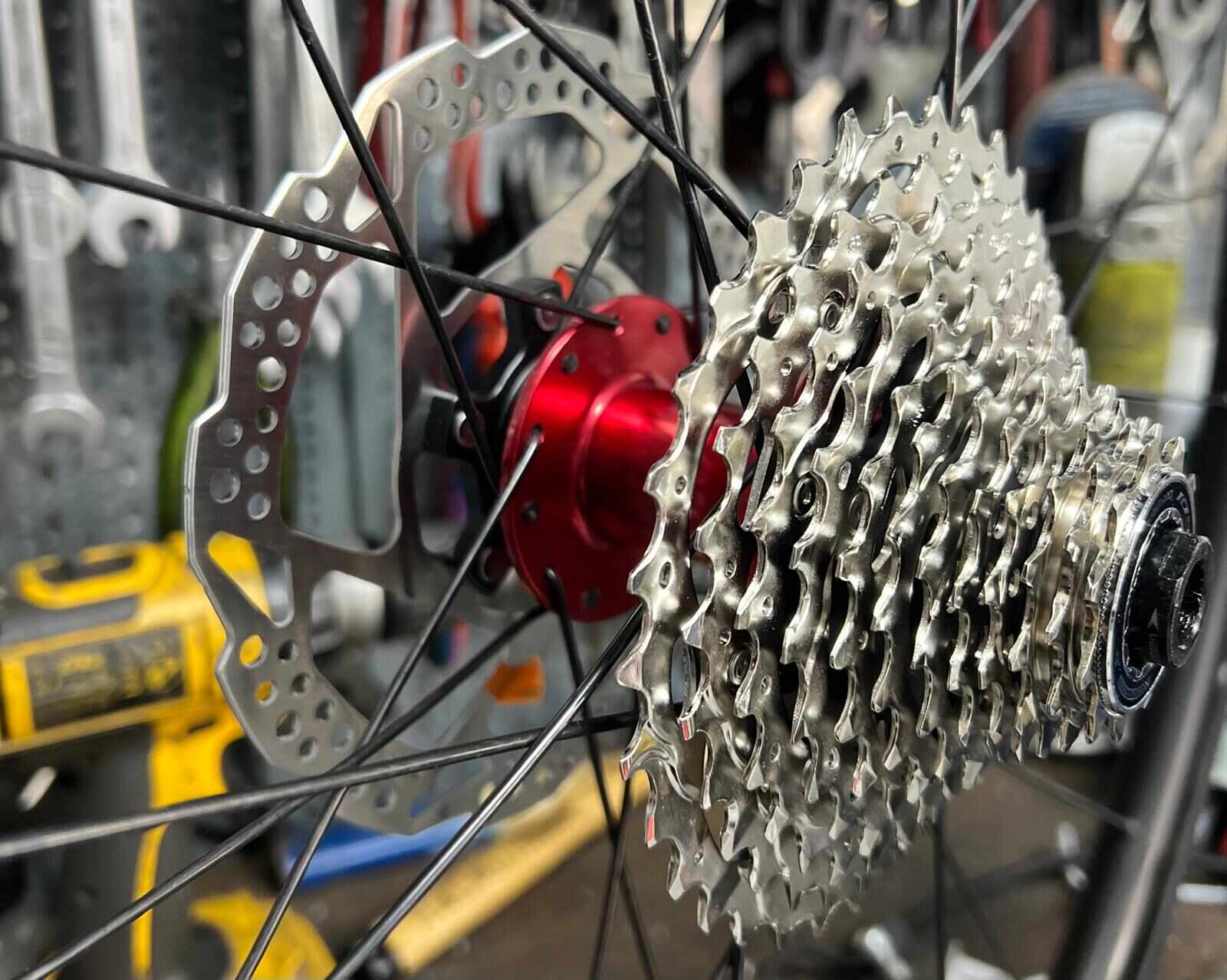 Kette & Kassette wechseln Berlin-Kreuzberg | BikeShop Friesen Kassette mit roter Nabe und Bremsscheibe in der Fahrradwerkstatt BikeShop Friesen Berlin-Kreuzberg — Kette und Kassette wechseln