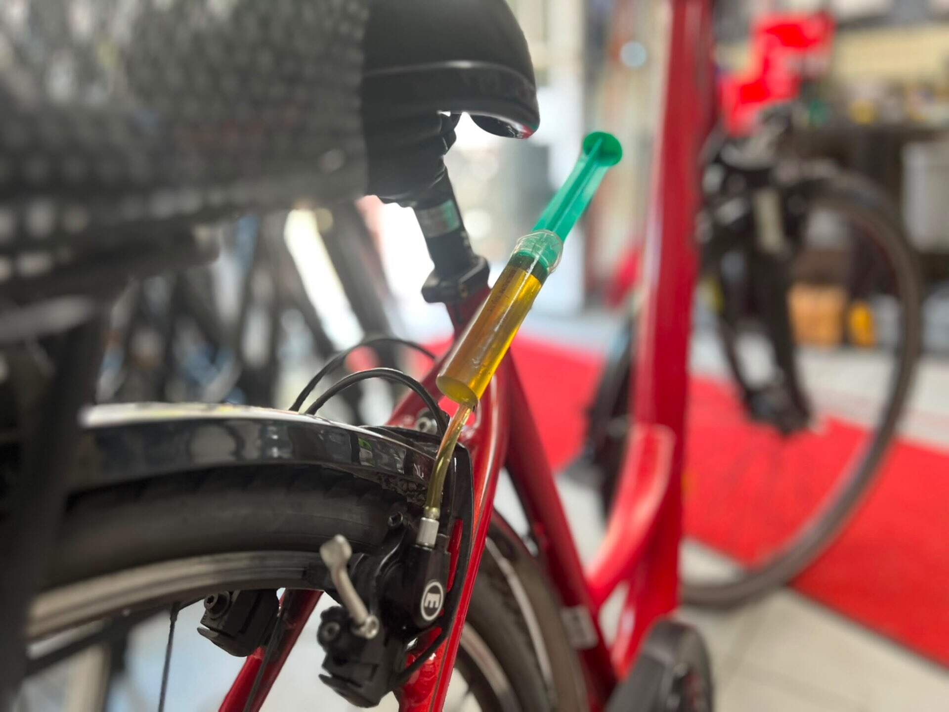 Hydraulische Bremsen entlüften | BikeShop Friesen Werkstatt Berlin Hydraulische Bremse entlüften — alte Bremsflüssigkeit wird abgezogen in der Werkstatt BikeShop Friesen Berlin-Kreuzberg
